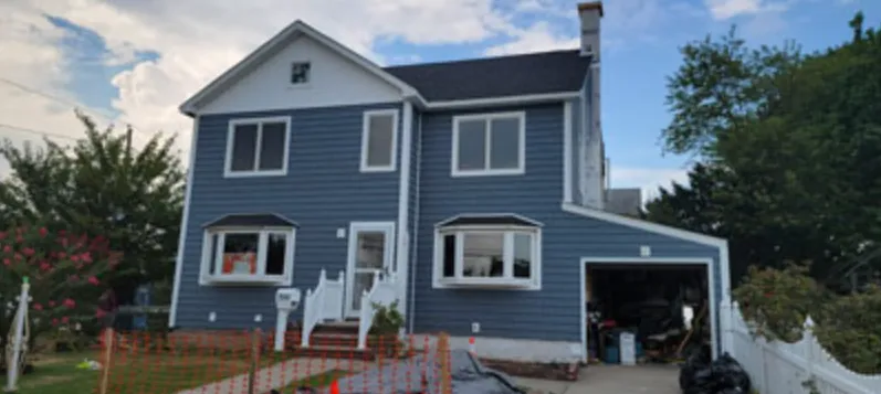 The same colonial finished in blue siding with white trim and bay windows
