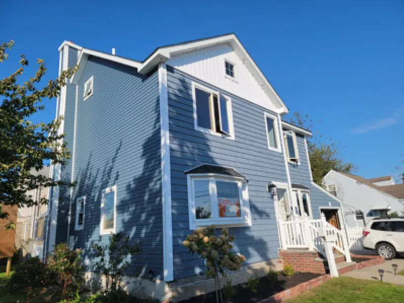 Two-story colonial finished in blue horizontal siding with white trim