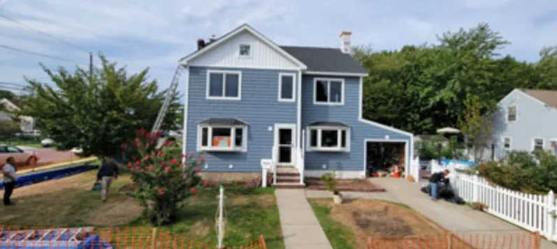 Blue colonial with new white bay windows and a white entry door