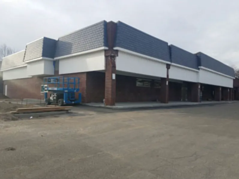 Retail strip with new mansard roof and white fascia under construction