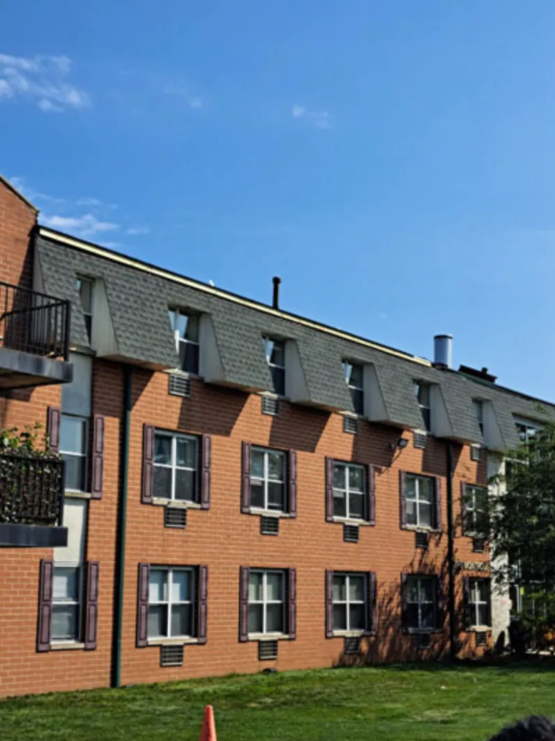 Brick apartment building with new mansard shingle roof and dormers